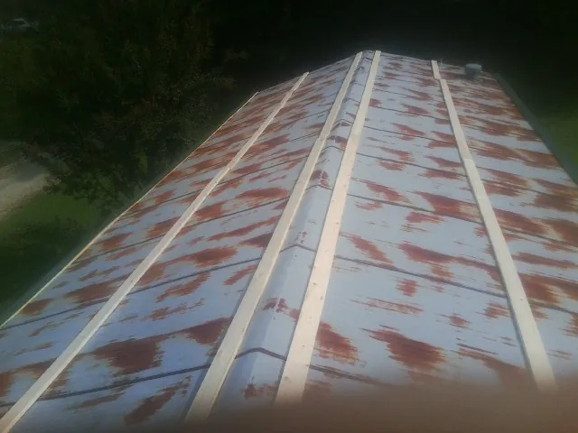 Rusted metal roof panels with new wood purlins before replacement — Storm Damage Roof Repair in Wilsonville by Roofing Brothers