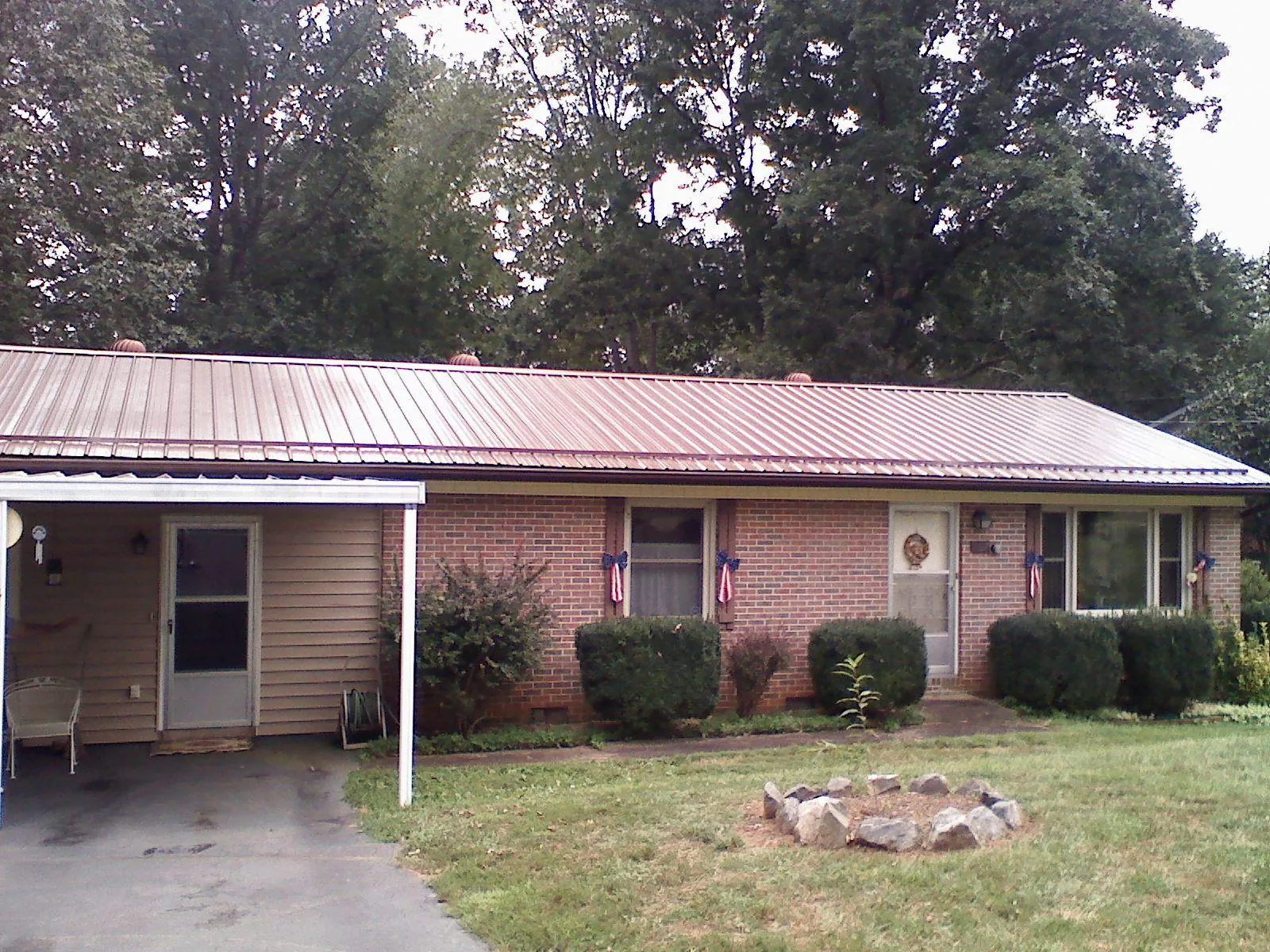 Bronze metal roof and carport on a brick ranch home — Roof Repair work by our crew in Wilsonville